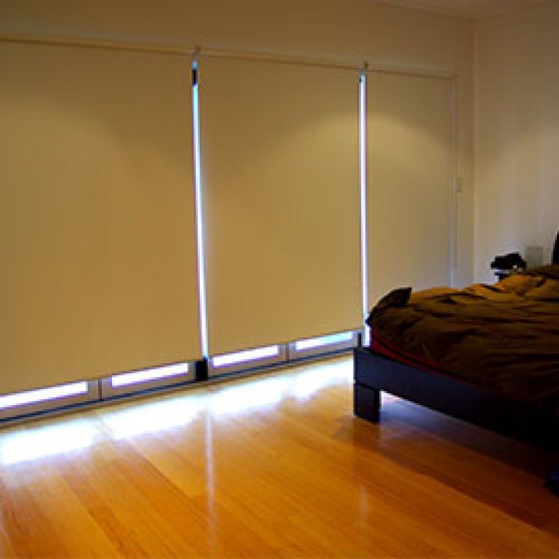 Window with horizontal blinds and comfortable bed in room